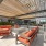 Outdoor roof deck terrace featuring shaded pergolas, red lounge seating, a fire pit, and  a granite bar with barstool seating.