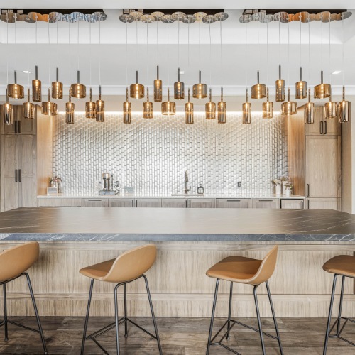 Entertainment kitchen with four barstools, gold pendant lighting and an oversized kitchen island