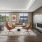 Community lounge featuring a dual sided fireplace, two orange chairs, a brown leather couch and table games, overlooking the roof terrace