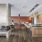 The Brookliner community lounge featuring a dual sided fireplace, marble kitchen island, gold pendant lighting, and a variety of seating options.
