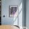A private conference room featuring a framed Coolidge Corner artwork piece and a view of lush outdoor greenery