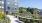 Roof deck terrace featuring lush greenery, a row of reclining lounge chairs, and a fire pit with Adirondack chair seating